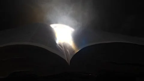 Book open wide close up bright light with smoke swirling in slow motion Stock Footage 205492596
