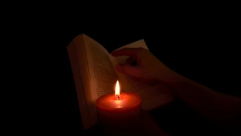 Book reading with a candle Stock Footage