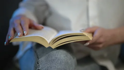 Book Reading Concept. Reading Kneeling Text, Close-up. Open Book On My Knees Stock Footage 157764398