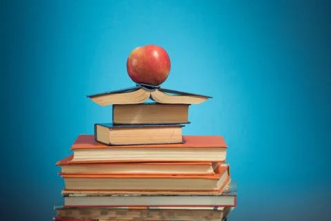 Book stack and apple on blue  education background,  back to school concept Stock Photos