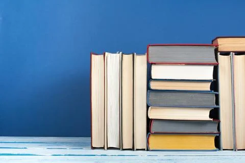 Book stack, hardback colorful books on wooden table and blue background. Ba.. 写真素材