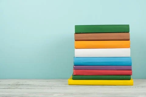 Book stack, hardback colorful books on wooden table and blue background. Ba.. 스톡 사진