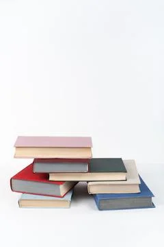 Book stack, hardback colorful books on wooden table, white background. Back.. Stock Photos