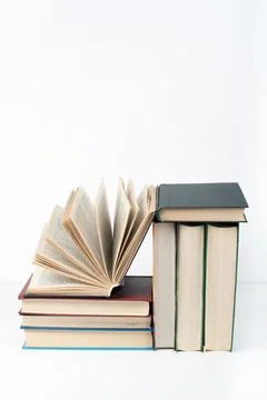 Book stack, hardback colorful books on wooden table, white background. Back.. Stock Photos