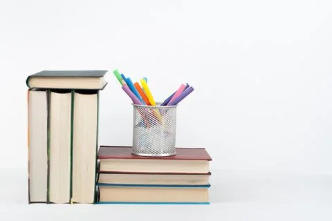 Book stack, hardback colorful books on wooden table, white background. Back.. 스톡 사진
