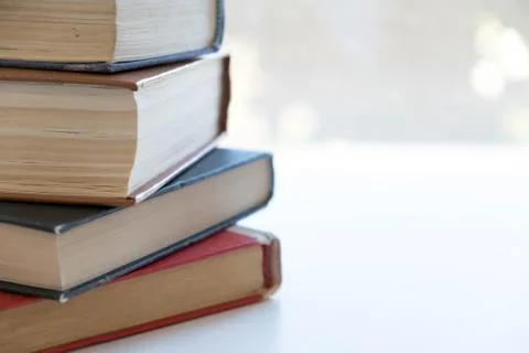 Book stack in the library room and blurred bookshelf, business and education Stock Photos
