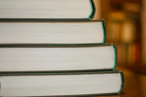 Book stack in the library room and blurred bookshelf for business and education. Stock Photos