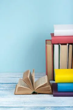 Book stacking. Open book, hardback books on wooden table and blue backgroun.. Stock Photos