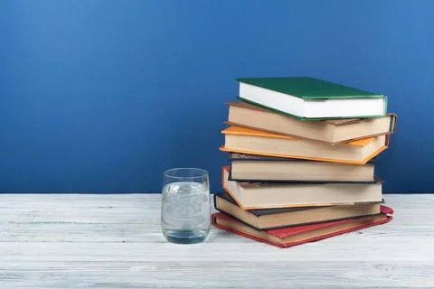 Book stacking. Open book, hardback books on wooden table and blue backgroun.. Foto stock