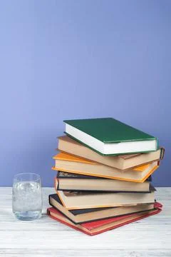 Book stacking. Open book, hardback books on wooden table and blue backgroun.. Stock Photos