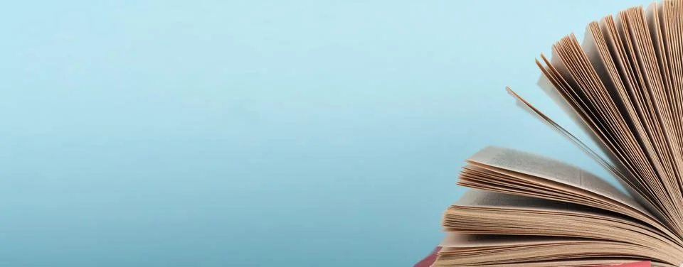 Book stacking. Open book, hardback books on wooden table and blue background. Stock Photos