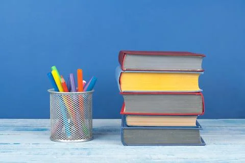 Book stacking. Open book, hardback books on wooden table and blue backgroun.. Stock Photos