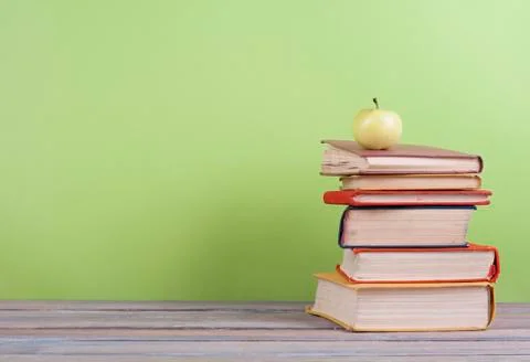 Book stacking. Open hardback books on wooden table and beige background. Back Stock Photos