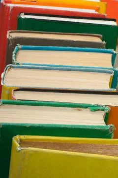 Book stacking. Open hardback books on wooden table and blue background. Back  Stock Photos
