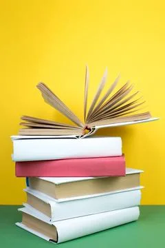 Book stacking. Open hardback books on wooden table and green background. Ba.. Stock Photos