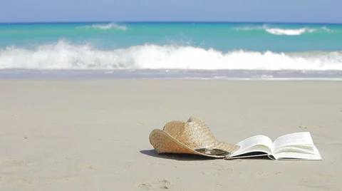 Book, sunglasses and straw hats on the beach. Relax concept Stock Footage