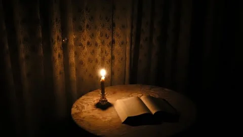 Book on the table with the candle Stock Footage 97846694