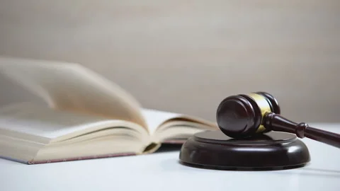 Book on table, gavel striking on sound block, government constitution, law order Stock Footage