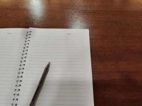 Book on the table with a pen Stock Photos