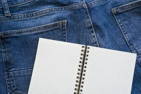 A book to write down ideas against the backdrop of blue jeans. Stock Photos