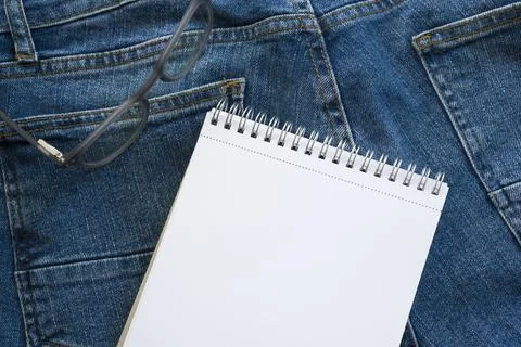 A book to write down ideas against the backdrop of blue jeans. Colors. Stock Photos