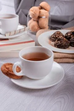 Book,cup of tea and chocolate on light background Stock Photos
