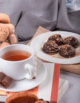 Book,cup of tea and chocolate on the table Stock Photos