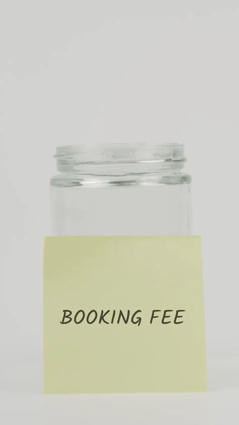 Booking fee text or word on yellow sticky note attached to glass jar Stock Footage 311683056