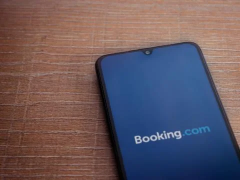 Booking.com app launch screen with logo on the display of a black mobile smar Stock Photos