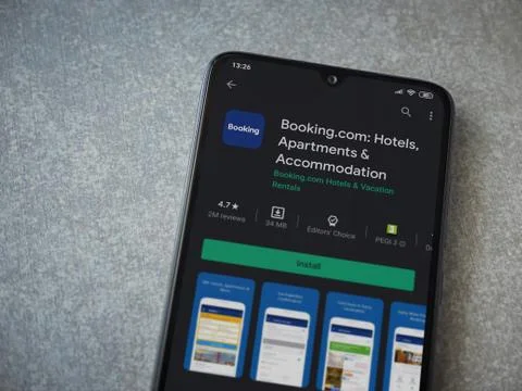 Booking.com app play store page on the display of a black mobile smartphone o Stock Photos
