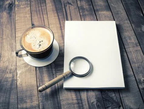 Booklet, magnifier, coffee cup Stock Photos