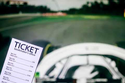 Bookmaker ticket on the background of the TV on which show the sports races the Fotos Stock