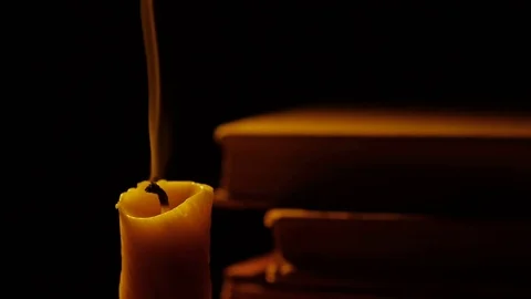 Books and candle. Fire and smoke. Light and blow out the candle. Slow motion. Stock Footage 77190888