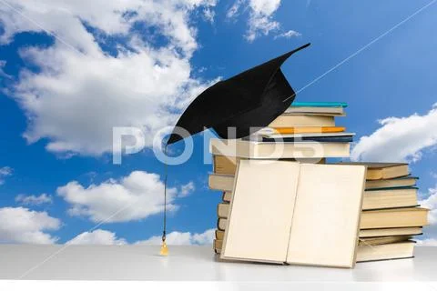 Books and mortarboard on wooden table Stock Photos