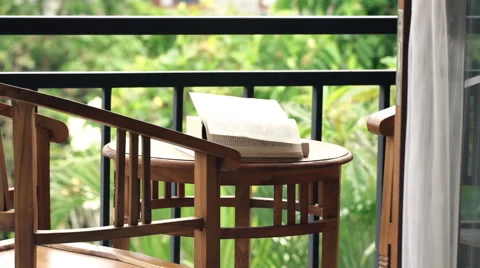 Book's pages turning by wind on table in garden Stock Footage 62744470