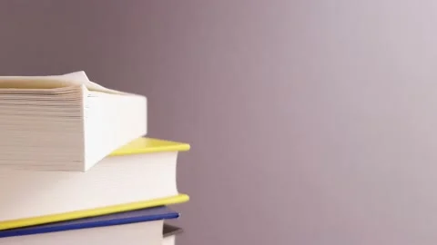 Books pile different colors close up on white gray background Stock Footage 147295137