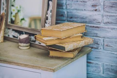Books stack on the old table in the background of mirrors, candles. 写真素材