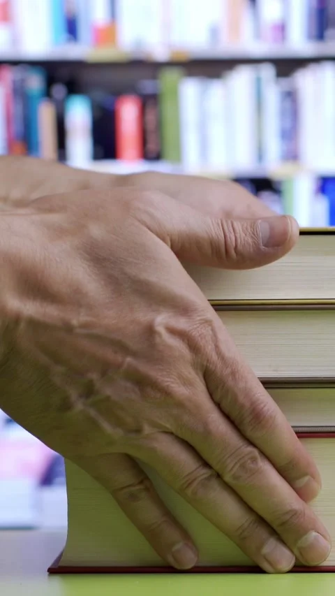 Books, table and person hands picking up books at library. Vídeos de archivo 337033670