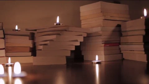 Books on the table lit by candles Stock Footage 72351578