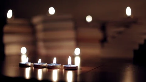 Books on the table lit by candles Stock Footage 72355795