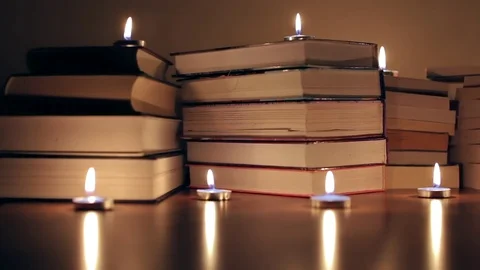 Books on the table lit by candles Stock Footage 72358559