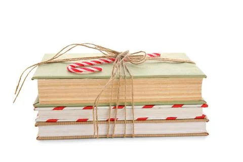 Books tied with string and candy cane on white background. Christmas celebrat Stock Photos