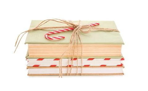 Books tied with string and candy cane on white background. Christmas celebrat Stock Photos