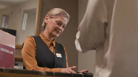 Bookstore Employee Processing Payment at Checkout Counter Stock Footage 310099905