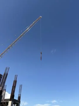 The boom and hook of a tower crane over the construction site of a Multisto.. Stock Photos