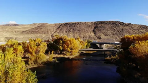 Boom Down Over Truckee River in Fall with Semi Truck Crossing Freeway Bridge Stock Footage 136057281