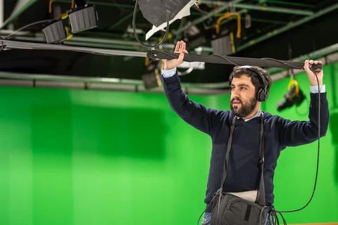 Boom microphone operator testing sound at TV studio. Stock Photos