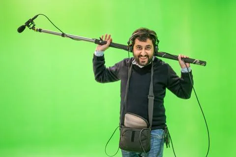 Boom microphone operator testing sound at TV studio on green key chroma Stock Photos