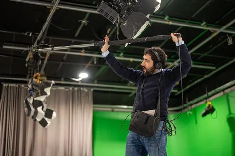 Boom microphone operator testing sound at TV studio. Stock Photos