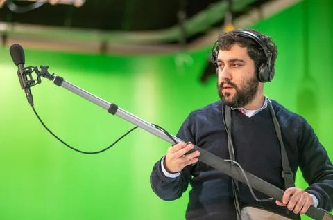 Boom microphone operator testing sound at TV studio. Stock Photos